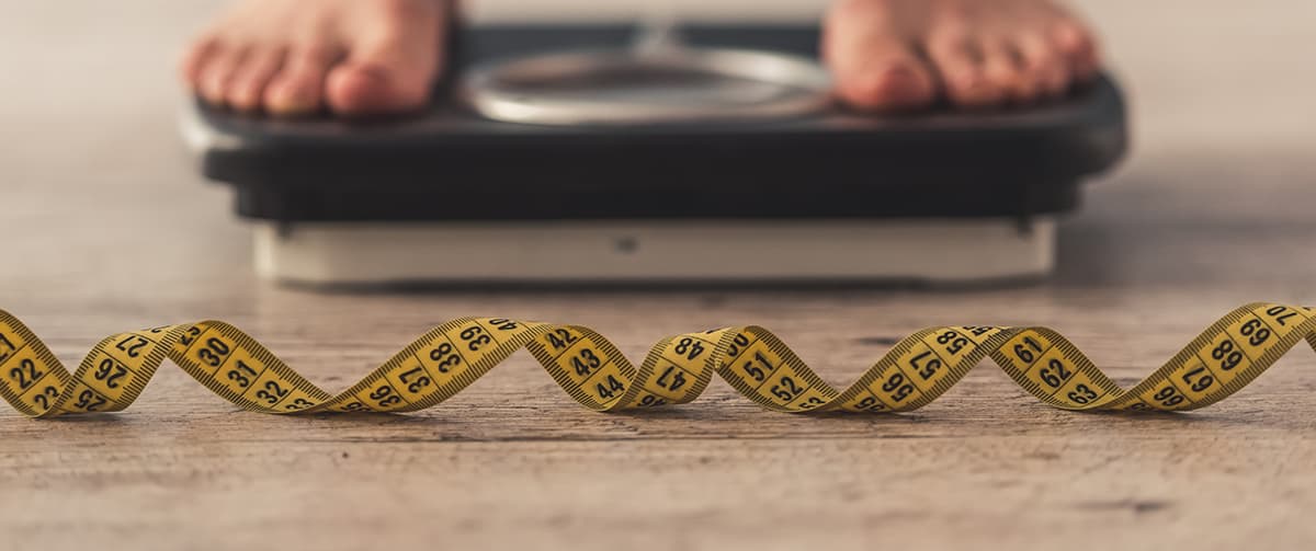 A tape measure in front of bathroom scales